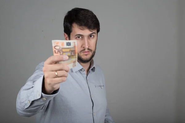 stock image young man with a beard, with euros in his hand