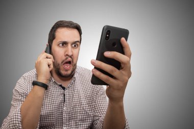 Genç adam akıllı telefon kullanıyor, telefonla konuşuyor.