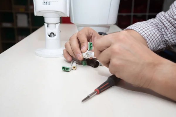 Hand inserting the Ethernet cable into the network security camera, equipment manipulation