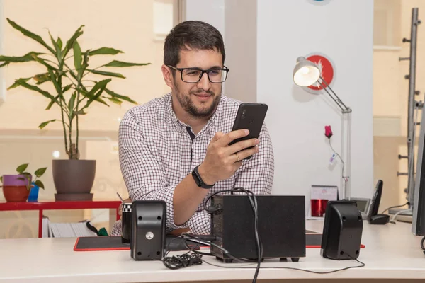 Young man using smartphone in the office — 스톡 사진