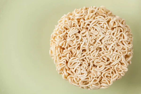 Close up Raw Instant noodles isolated on a green plate with spac