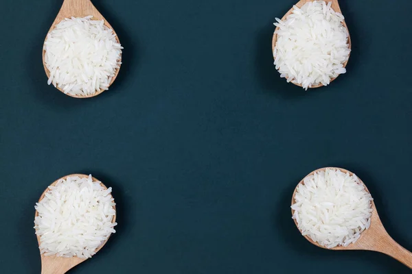 Riso lavorato nel cucchiaio di legno messo sulla tavola verde con spazio — Foto Stock