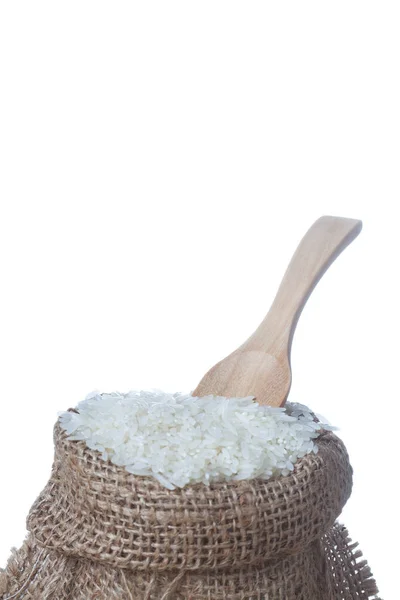 Il riso a sacco e cucchiaio di legno isolato su sfondo bianco — Foto Stock