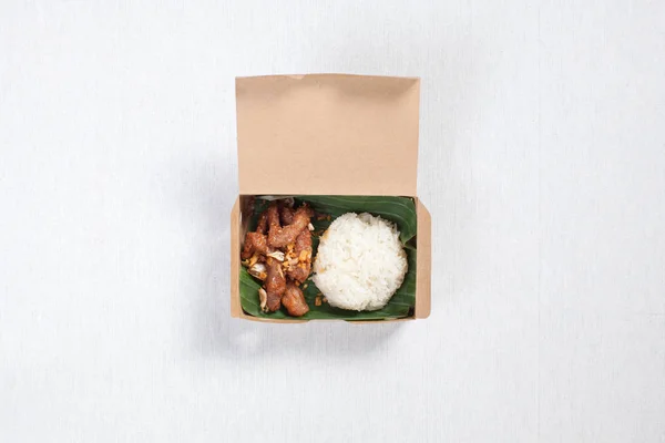 튀긴 돼지고기를 갈색 종 이 상자에 넣고 흰 식탁보에 얹은 끈적끈적 한 밥 — 스톡 사진