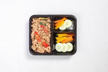 Fesleğen ve kıyma ile karıştırılmış pirinç siyah plastik kutuya konur, beyaz bir masa örtüsü takılır.