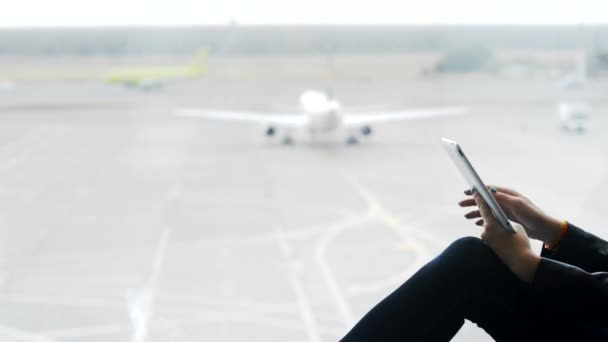 Mujer joven usando tableta moderna en el aeropuerto — Vídeos de Stock