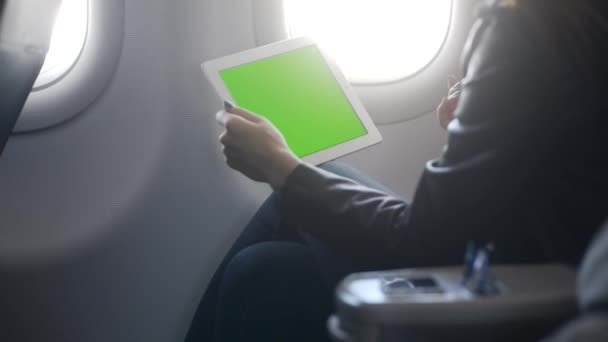 Mujer joven usando tableta en avión confort — Vídeo de stock