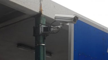 metal bir stand üzerine monte arka plan korumalı kamera telleri hareketi izlemek için arabaya bakar ve içinde oturan insanların fotoğraflarını çeker.