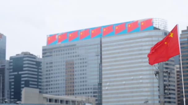 Гонконг Китай размахивает красным флагом с желтыми звездами знак глобальной экономики в деловом центре города. символизируя визуальное подавление сверху политики этого города — стоковое видео