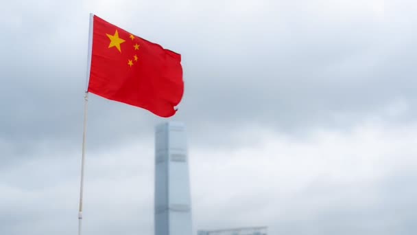 中国国旗插在旗杆上，背景是多云的天空和世界办公楼 — 图库视频影像