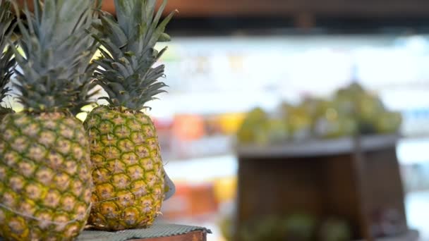 手にエキゾチックなパイナップルを取る若い女性旅行者は、アジアのスーパーマーケットです. — ストック動画