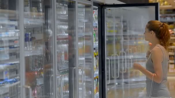 Junge amerikanische Kundin kauft Fruchtsaft im Lebensmittelladen. — Stockvideo