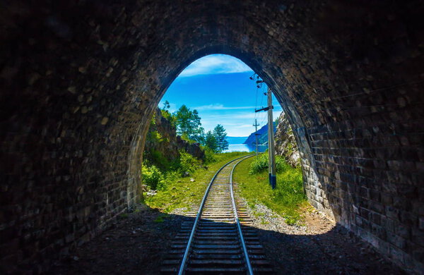 Light at the end of the tunnel on Circum-Baikal railway. Conceptual background representing hope, faith, endurance, perseverance, the desire to achieve the goal and exit from a difficult situation.