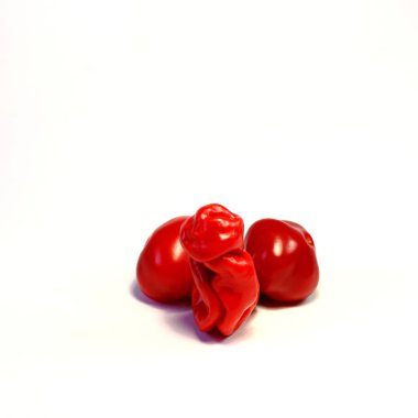 Red chili peppers making up the erection penis with testicles on light background