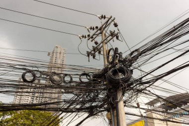 Somut ayağı üzerinde izolatörler ve pis elektrik telleri sanayi arka plan. Teller ve kablolar, Filipinler, düzensiz bağlantı. Güç kablosu ve telefon hatları yüklü karmakarışık etmek