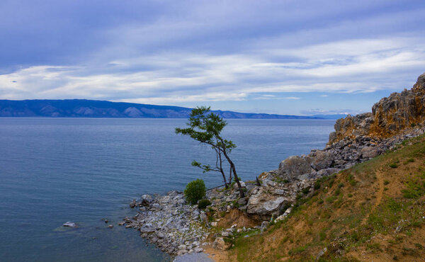 Evening view with Cape Burkhan at the Olkhon Island on Small sea of Baikal lake. Summer vacation in the heart of Siberia. The sacred place of Buddhists and shamans.