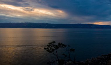 Baykal gölü veya Küçük deniz, Sibirya'daki Olhun Adası'nda Burkhan Burnu ile akşam manzarası. Sibirya'nın göbeğinde yaz tatili. Budistlerin ve şamanların kutsal yeri. Dünyanın en derin berrak gölü