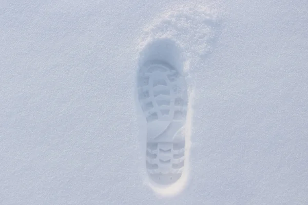 Man footprint in a fluffy white winter snow. Human trace in deep snow. Winter scenic. Simple trace of boot in the fallen snow.