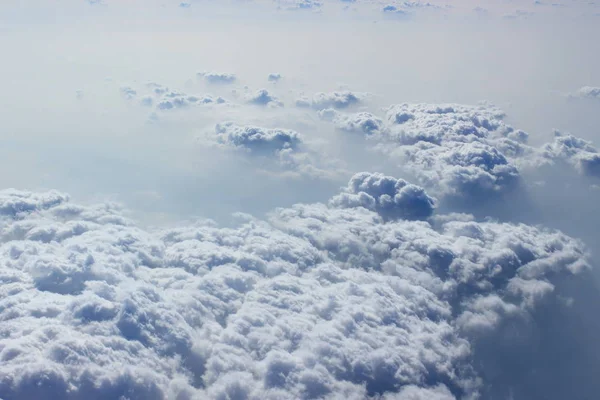 Cennet gibi kabarık sütun bulutlar ve uçak penceresinden kalın peçe. Bulutların üstünde uçan. Soyut cennet arka plan. Özgürlük kavramı