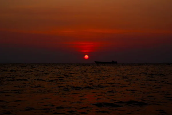 Bateau solitaire dans la mer sous le coucher du soleil — Photo