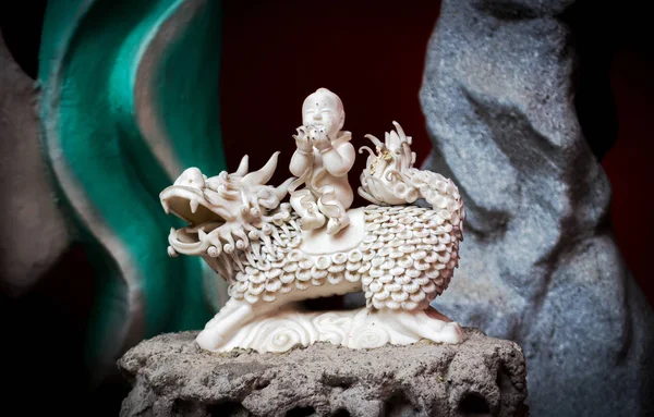 Statuette of Qilin carrying baby on his back — Stock Photo, Image