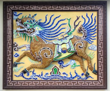 Qilin Çin geleneksel eski seramik duvar resmi. Çin masalkirin, bir at gövdesi ve Nha Trang Çin tapınağının duvarında bir ejderha kafası ile, Vietnam
