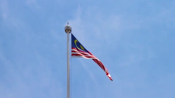 きれいな青空に向かう風に揺れる旗柱に乗ったマレーシアの国旗 — ストック動画