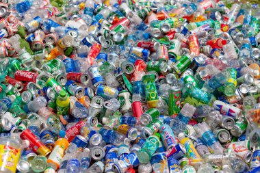 Çöplükte berrak plastik şişe atıkları ve bira tenekeleri yığını