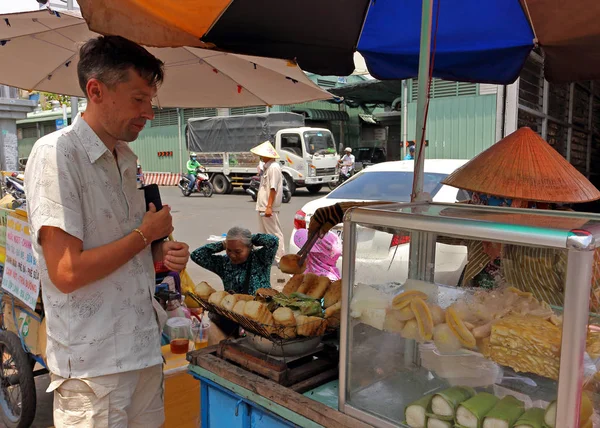 El hombre europeo come en el mercado asiático — Foto de Stock