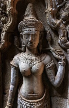 Apsara Deva 'nın eski bas-rahatlaması Angkor Wat tapınağındaki duvara oyulmuş eski bir taş. Seçici odak, gürültü görünür film tahılı