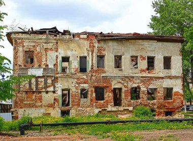19. yüzyılda yıkılmış camları olan terk edilmiş eski bir taş binanın cephesi.