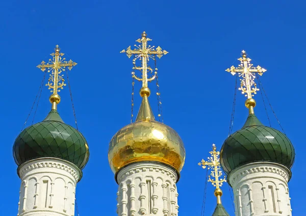 Gold domes Orthodox church sparkling in the sun on the background of bright blue sky in summer day, Zaraysk, Russia