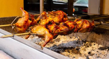 Lechon manokunun ya da kızgın terbiye edilmiş tavuğun kızgın kömürün üzerinde pişirilmesi Filipinli sokak mutfağıdır. Düşük ışık atışı, seçici odaklanma