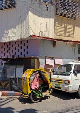 Manila, Filipinler - 24 Eylül 2018: Bisikletten çıkarılan eski üç tekerlekli bebek arabası, gündüz vakti şehir yolunda duruyor. Yolcu ya da yük taşımak ya da dinlenmek için kullanılır