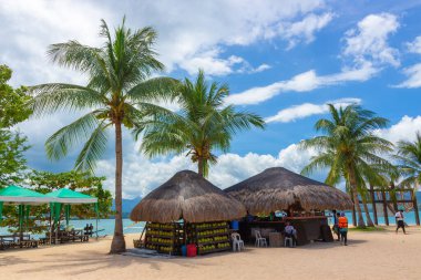 Palawan, Filipinler - 27 Eylül 2018: Tropik bir adada palmiye ağaçları altında genç hindistan cevizi satmak için bar ve bambu bungalovu. Plaj istirahatı ve dinlenme.