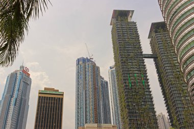Kuala Lumpur, Malezya - 11 Mart 2019: alacakaranlıkta Kuala Lumpur gökdelenleri. Ön cephesinde yeşil bitkiler büyüyen eko bina.