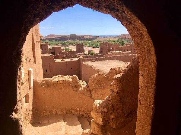 モロッコのOuarzazate市の近くにあるAit Ben Haddouの古代のAit Benhaddou KasbahまたはKsarのアーチ窓からの眺め 多くの映画が撮影された有名な古代の床屋カスバ ノイズ目に見えるフィルム穀物 — ストック写真