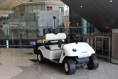 Hong Kong, Çin - 7 Ekim 2018: Hong Kong Uluslararası Havalimanı içinde insan taşımacılığı için beyaz elektrikli golf arabası veya at arabası