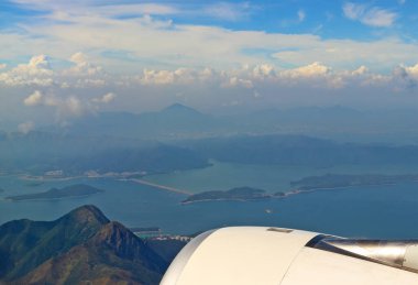 Hong Kong adaları üzerinde lombolik uçaktan yumuşak hava manzarası. Adaların üzerinde yoğun sis bulutu var. Seyahat ve reklam için korku arka planı.