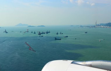 Uçan uçaktan Hong Kong adaları üzerindeki hava manzarası. Gökyüzü, bulut ve denizdeki küçük gemiler bir araya geldi. Seyahat için harika bir geçmiş. Seçici odak