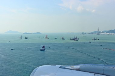 Hong Kong Uluslararası Havalimanı 'na indikten sonra uçak lombozundan deniz manzarası. Yüksek hızlı uçak ve seçici odaktan kısmi bulanıklık