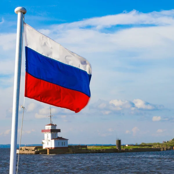 Rusya 'nın St. Petersburg eyaletindeki Kronstadt limanının arka planında dalgalanan Rus bayrağı. Bulanık hareket, seçici odaklanma