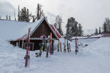 Ergaki, Krasnoyarsk Krai, Rusya - 25 Mart 2020: Alp kayakları ve snowboard 'lar dağlardaki bir kayak merkezinin kireçtaşı yakınında kar yığınında dururlar. Aktif kış aile tatili konsepti