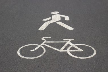 Asfaltta beyaz yol izleri var. Asfaltta yayaya ve bisiklete ait izler var. Yaya ve bisikletçiler için kaldırım aynı anda.