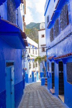 Chefchaouen, Fas 'ın Medine şehrinde boş dar bir şerit maviye boyanmış. Kuzey Afrika 'daki eski kasaba için geleneksel mimari.