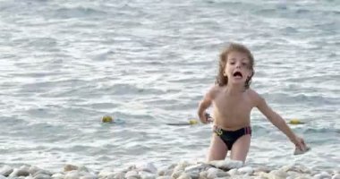 Denizde yüzme sevimli kıvırcık saçlı çocuk.