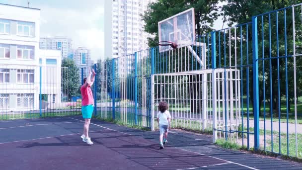 Vader en zoon spelen basketbal. Gezonde levensstijl. — Stockvideo