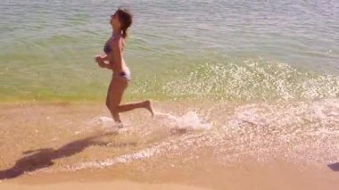 Deniz kenarı boyunca çalışan mutlu bir aile. Ağır çekim.