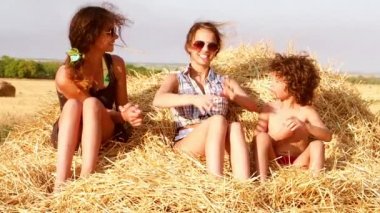 İki sevimli kız kardeş ve bir haystack üzerinde oynarken küçük kardeşim. Ağır çekim.