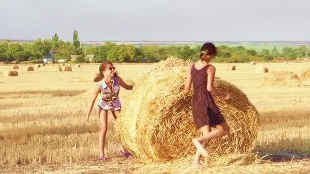 Twee Leuke Meisjes Rennen Spelen Een Hooiberg Slow Motion — Stockvideo
